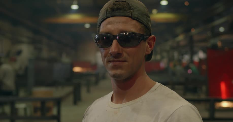 A man looks up smiling in a workshop
