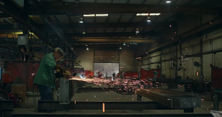 Sparks fly around a man using a grinding tool
