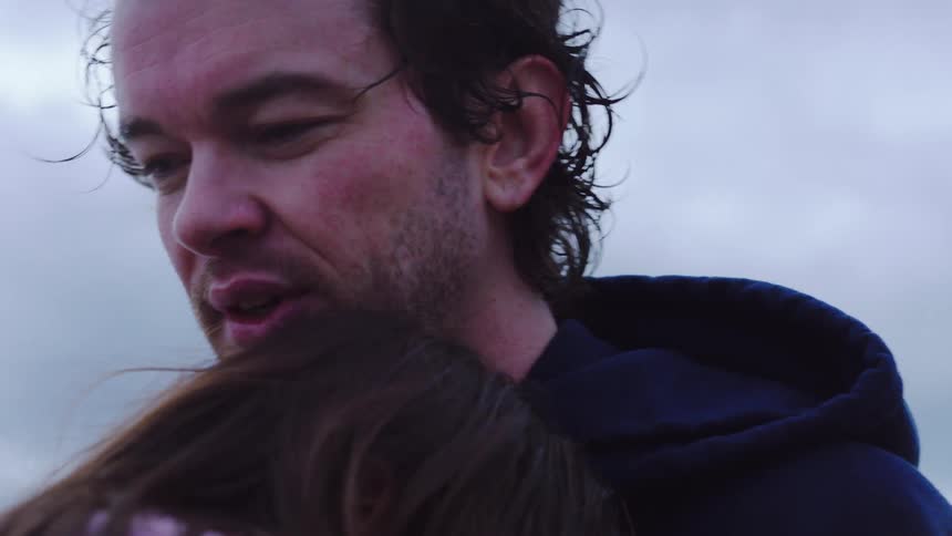 A man and woman hugging on the beach