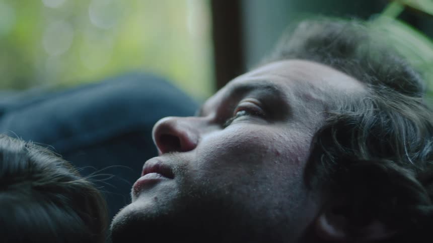 A man and woman laying around cuddling