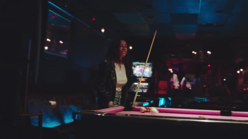 Man and a woman playing pool in a bar