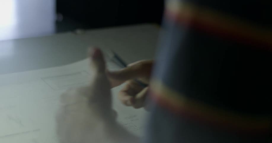 A man points at a blueprint and motions his hands