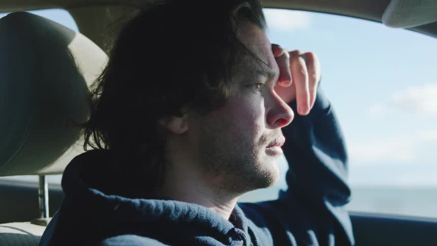 Close up portrait of a young man driving a vehicle during daytime