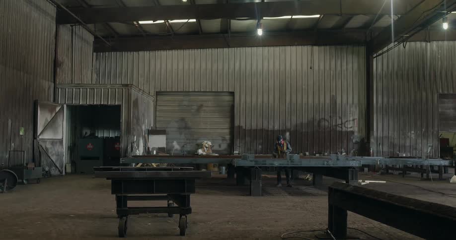 Man works on metal in a warehouse
