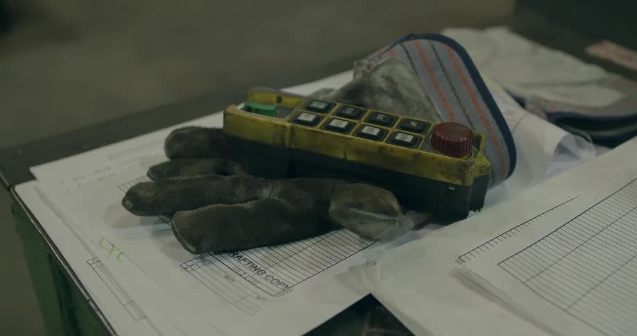 A button controller sits on a dirty work glove