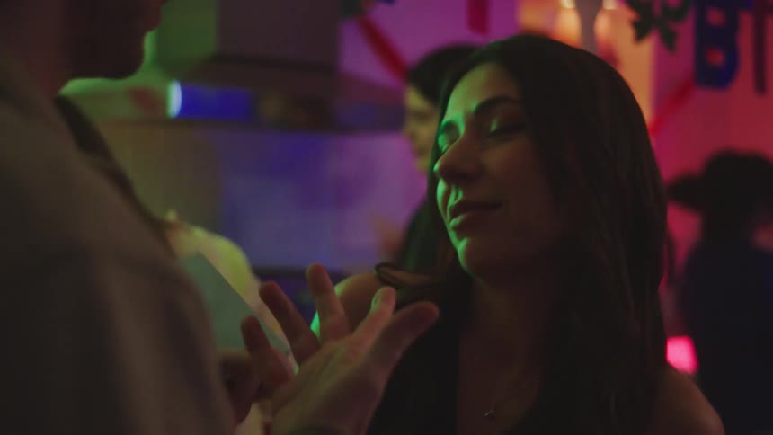 The woman hands a man a birthday card at the party