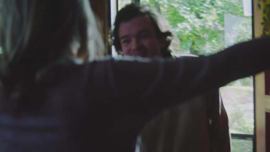 Man enters a house and hugs a woman