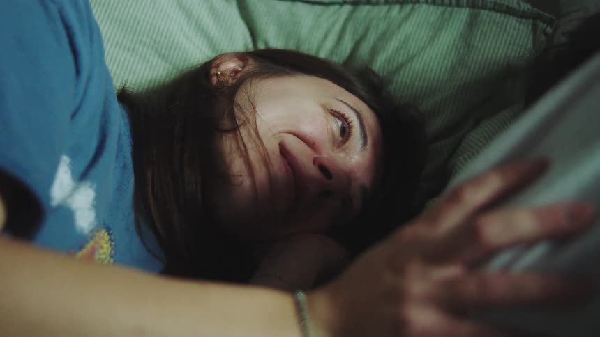 A man and woman cuddling in a bed
