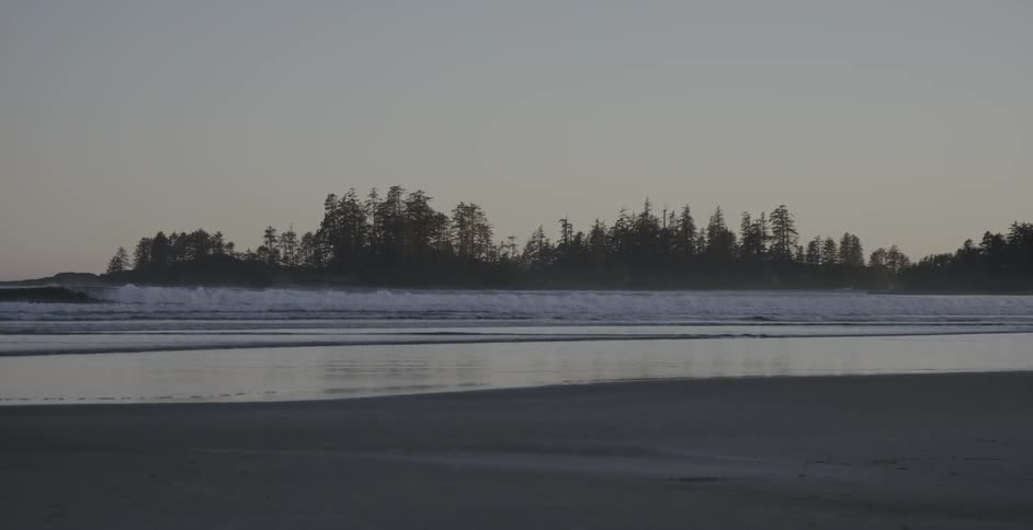 Ocean tide rolling in on a beach at dusk