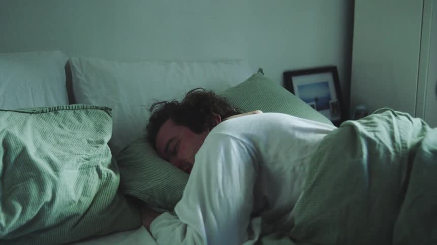 The woman gets out of bed as the laying down man laughs