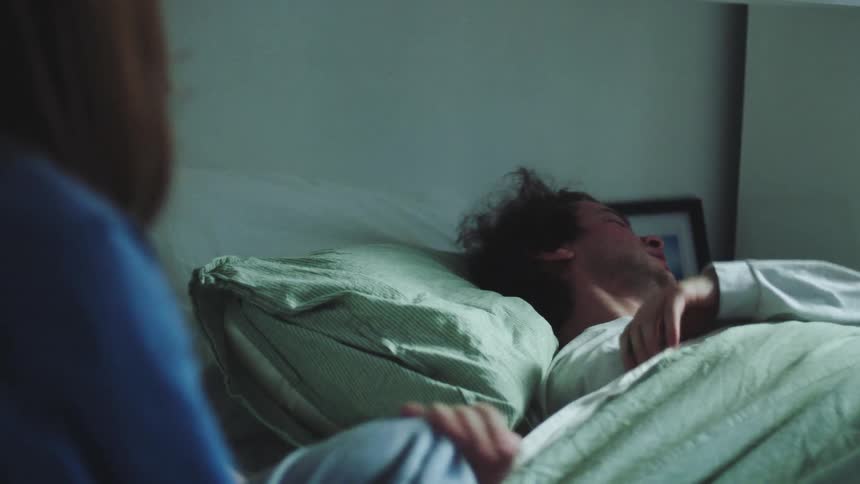 Woman lies down after trying to convince a man to get out of bed