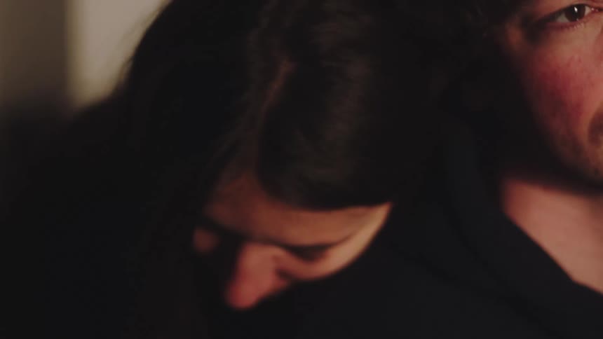 The woman hugs the man from behind