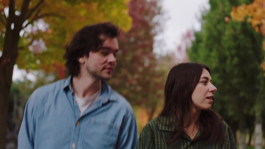 A young couple walking together outdoors in a suburban city