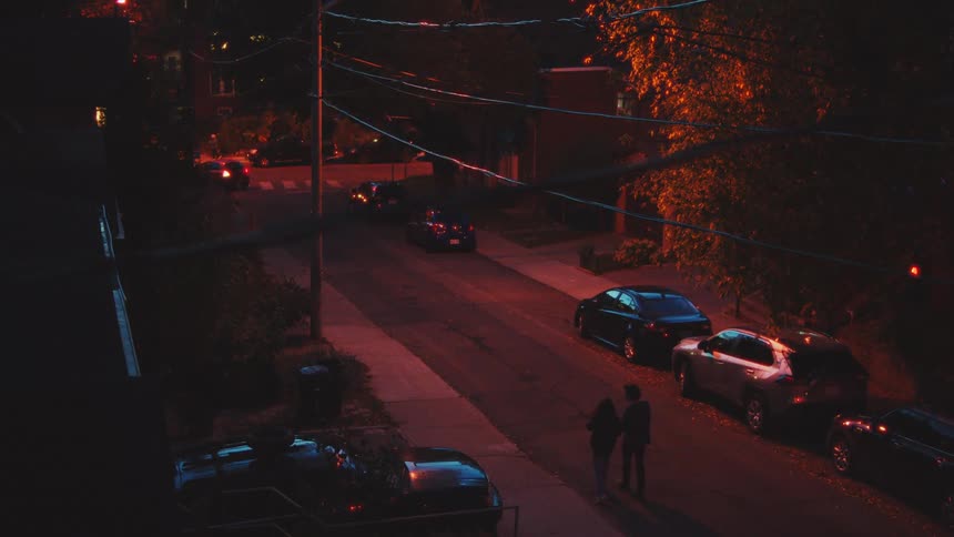 The couple walk on the road at night