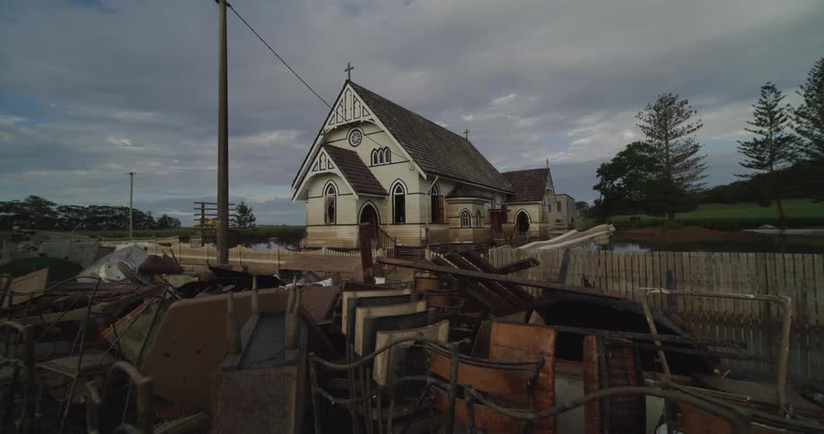 Stacked furniture packed outdoors in front of a church in a rural area during daytime
