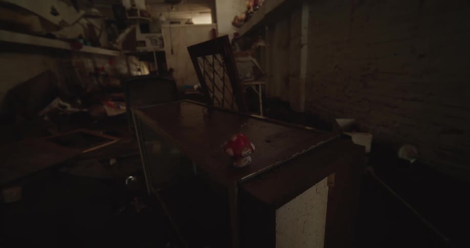 Disorganized interior room with overturned furniture scattered objects and low lighting