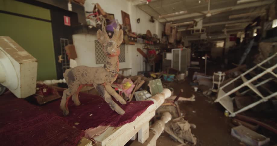 An abandoned building filled with furniture scattered around the room