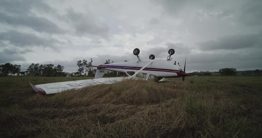 A plane that is upside down in a field