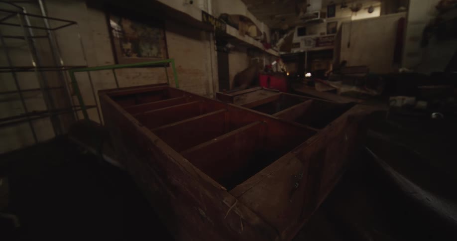 A garage is filled with furniture including a wooden shelf lying on the ground
