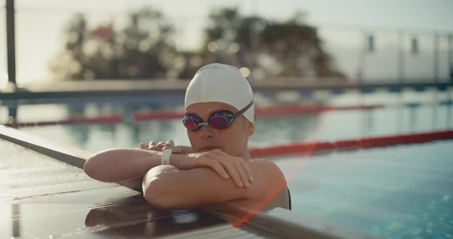 The woman in the pool leans over the edge