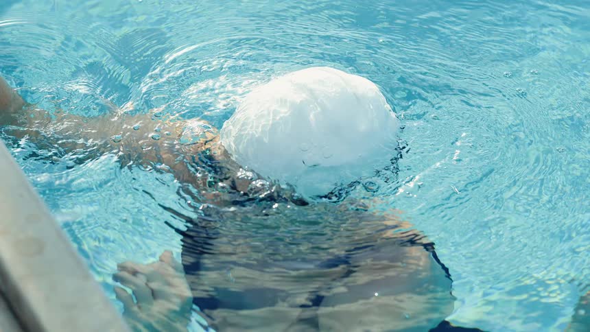 A woman swimming out of the water in a pool