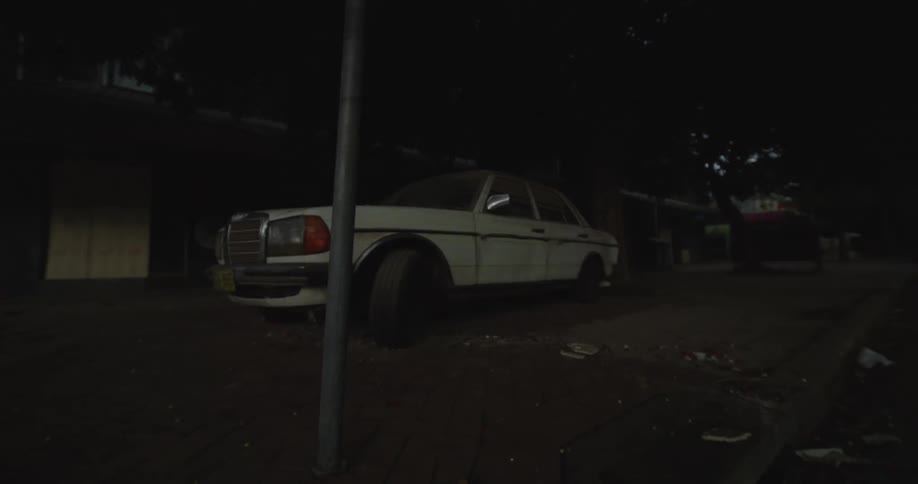 A car sitting on a street at night