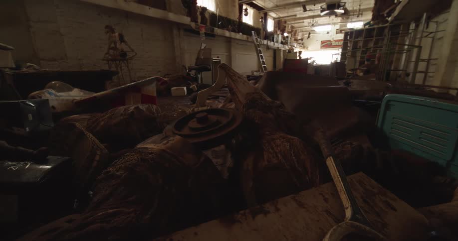 An abandoned room at midday cluttered with neglected belongings and scattered furniture