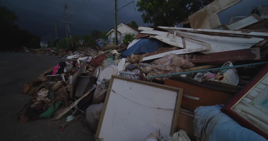 Household debris scattered along public road after natural disaster