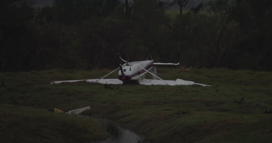 Small airplane lying upside down in a field