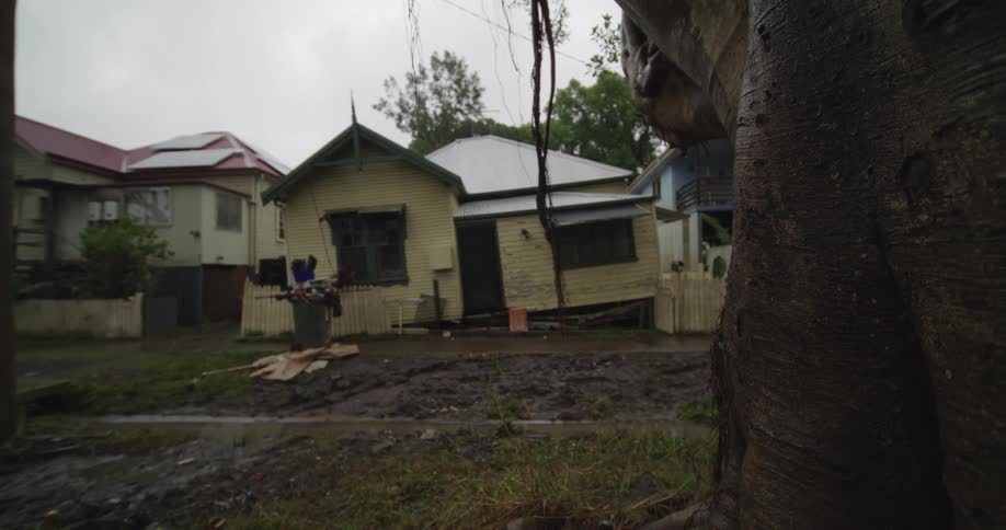 A street view shows buildings lining the sides of an unpaved road at midday