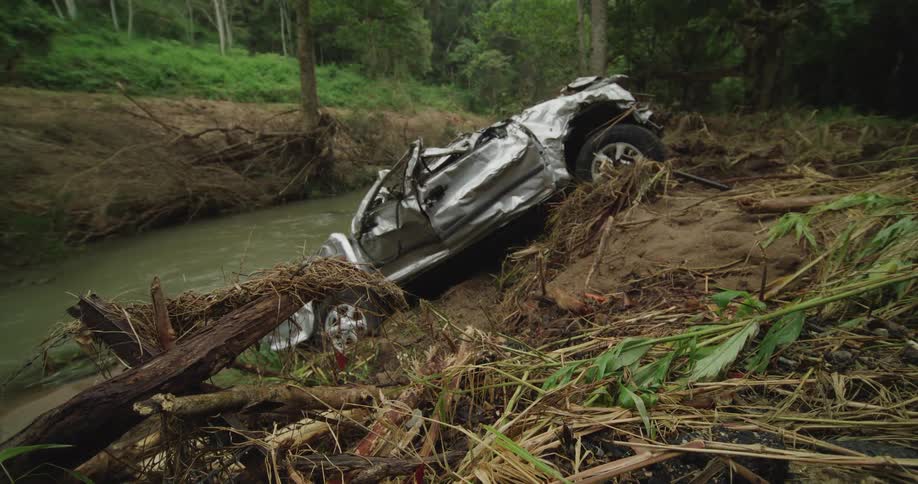 Smashed car on the bank next to a stream