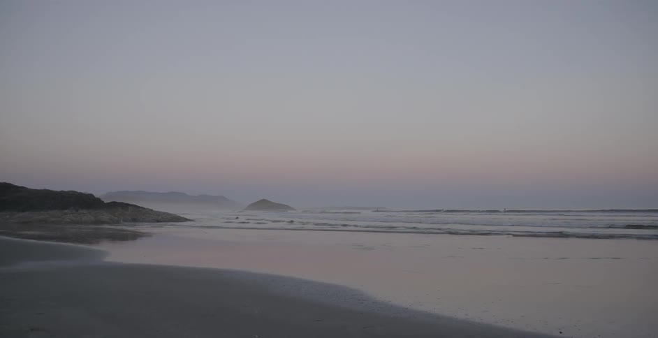 Ocean water flowing onto beach at dusk