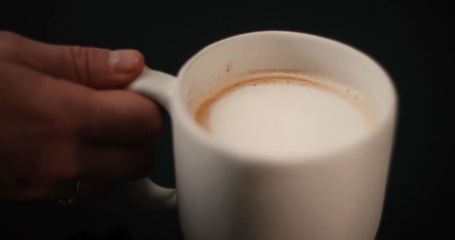 The man lifts the cup of coffee