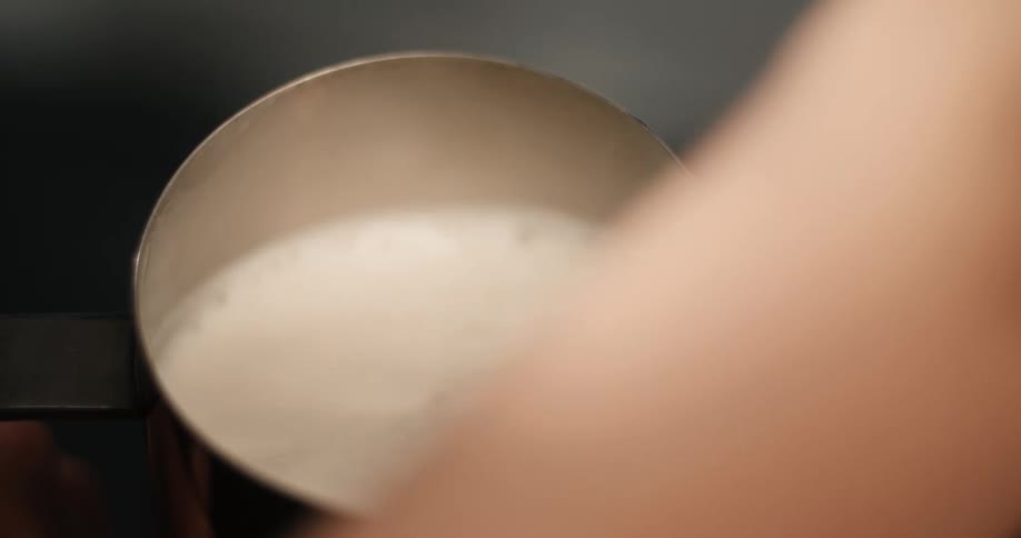A person frothing milk