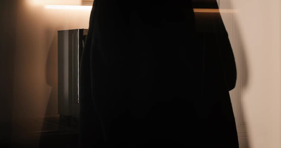 Adult woman standing up preparing coffee on an espresso machine indoors during day time