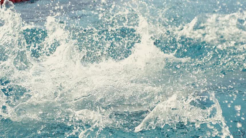 Water splashes as a woman dives into a swimming pool