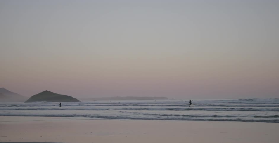 A person is wading through the waves in the beach