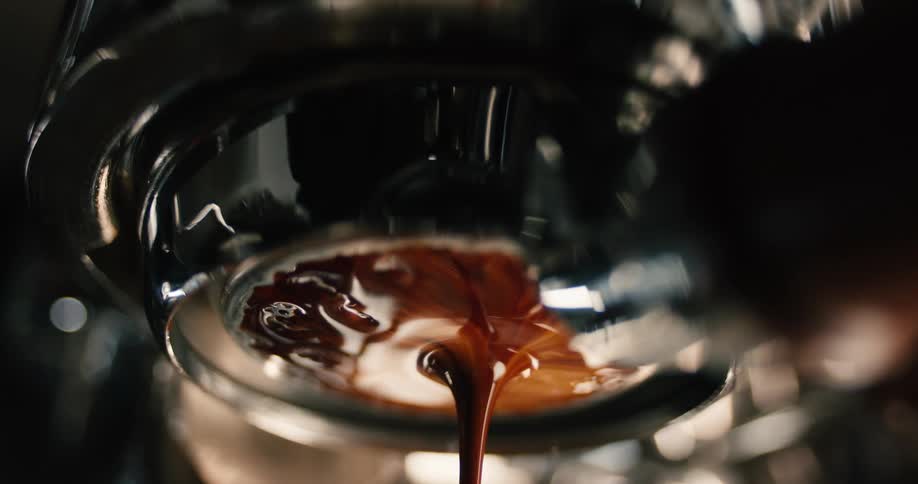 Dark espresso flowing from portafilter