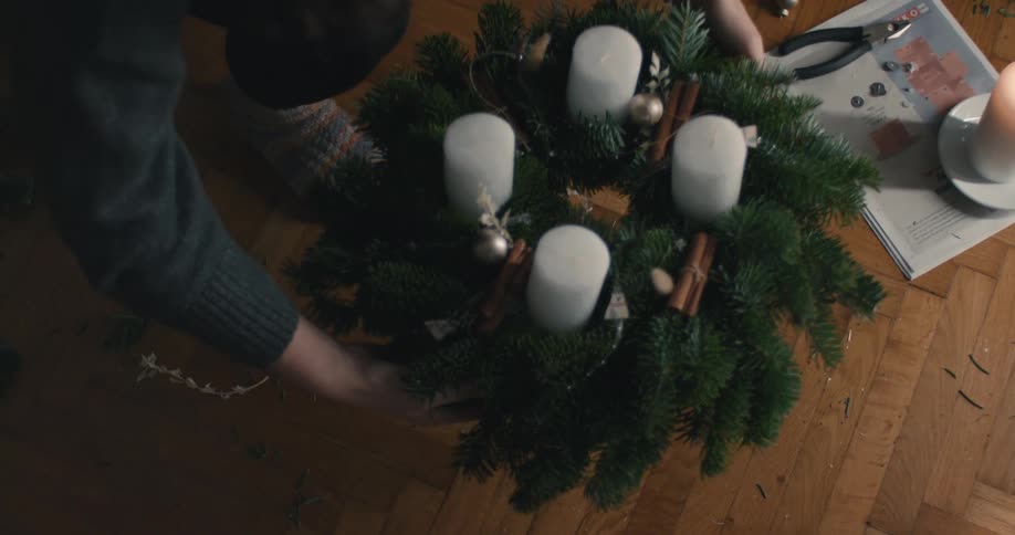 A person picking a wreath up off the floor