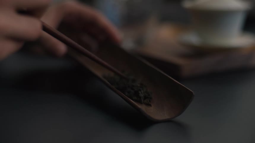 Close up of a person arranging and sorting tea leaves on a half pipe