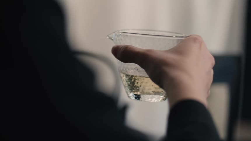 A person swirling a glass of tea