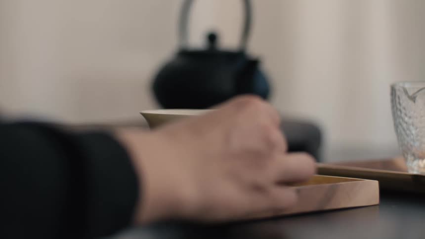 A person opening a cup of tea