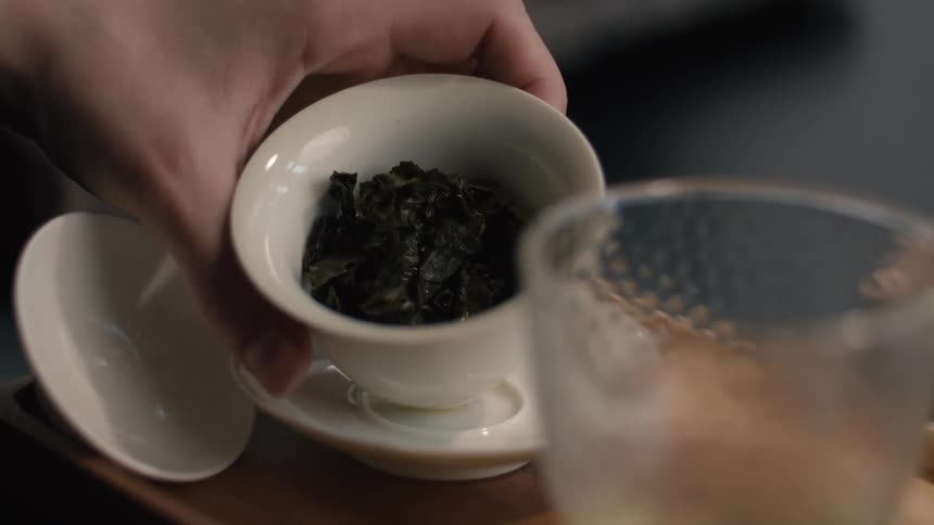 The hand is tipping the tea cup to show what is inside