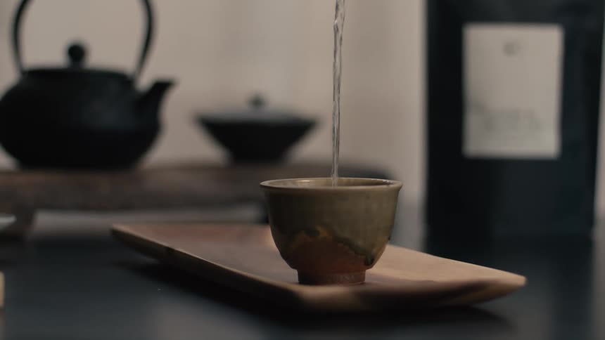 A person pouring tea into a cup