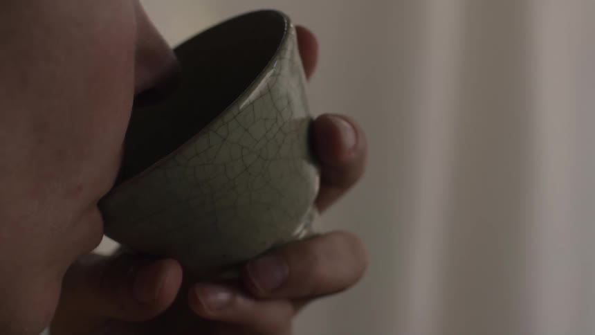A person drinking tea from a cup