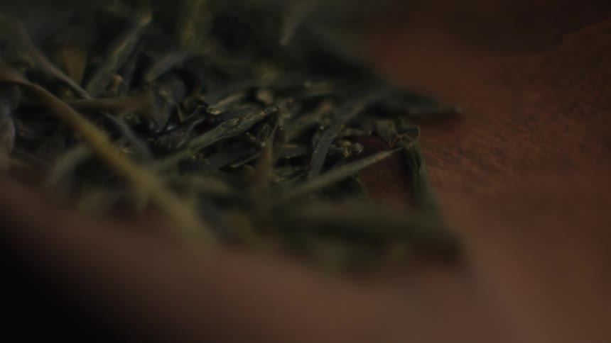 A close up of a spoon with tea leaves in it