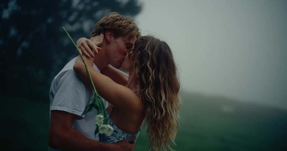 A man and woman kissing each other outdoors