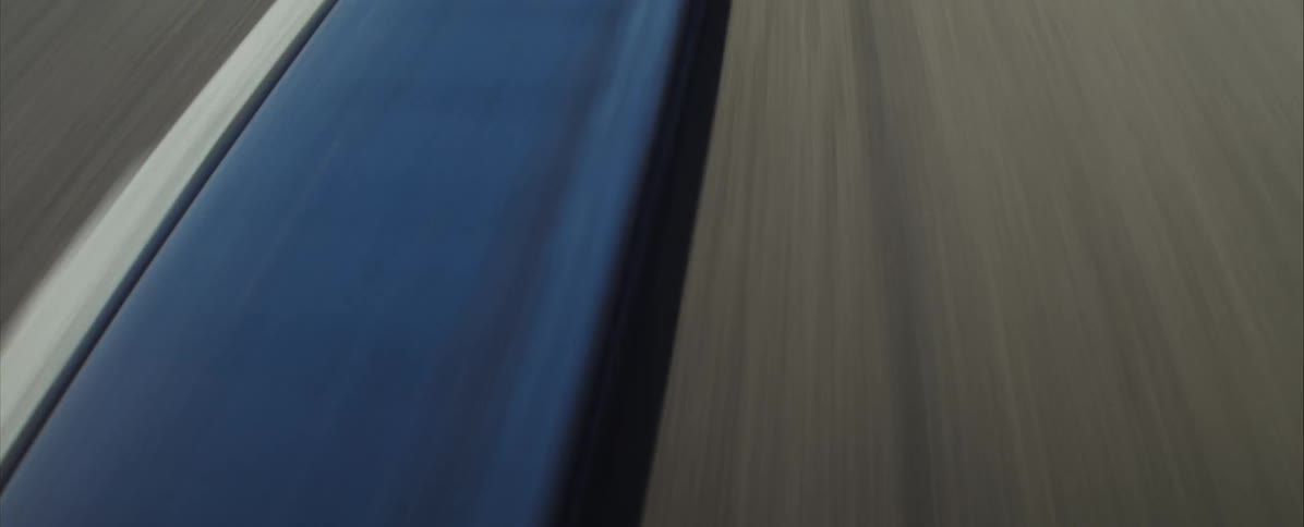 Blue and black striped curb marking on the edge of an asphalt track seen up close