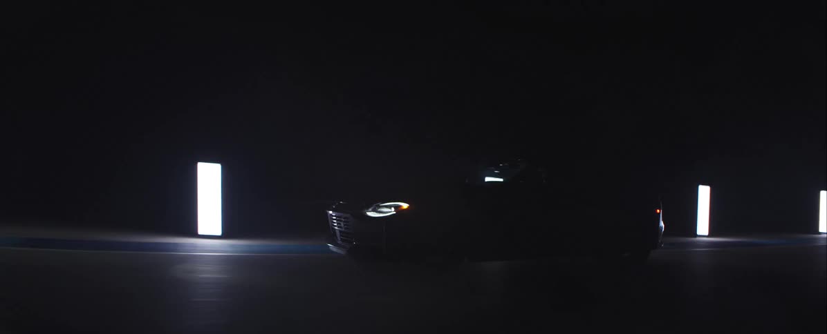 The car is driving pasts the rectangle lights along the edge of the road in the darkness