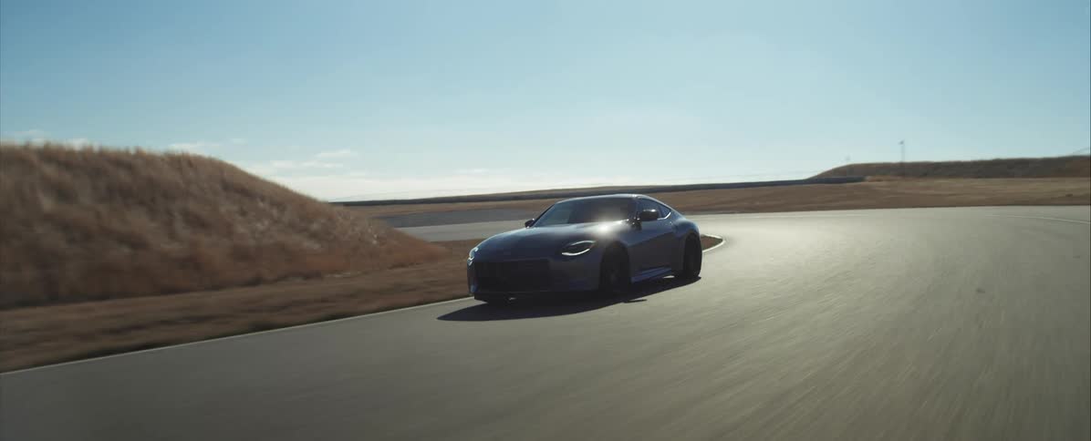 Black sports car travels around a curve on the highway